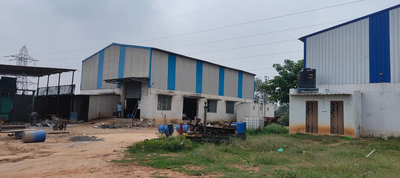 Industrial shed building exterior with water tank and green surroundings Coimbatore