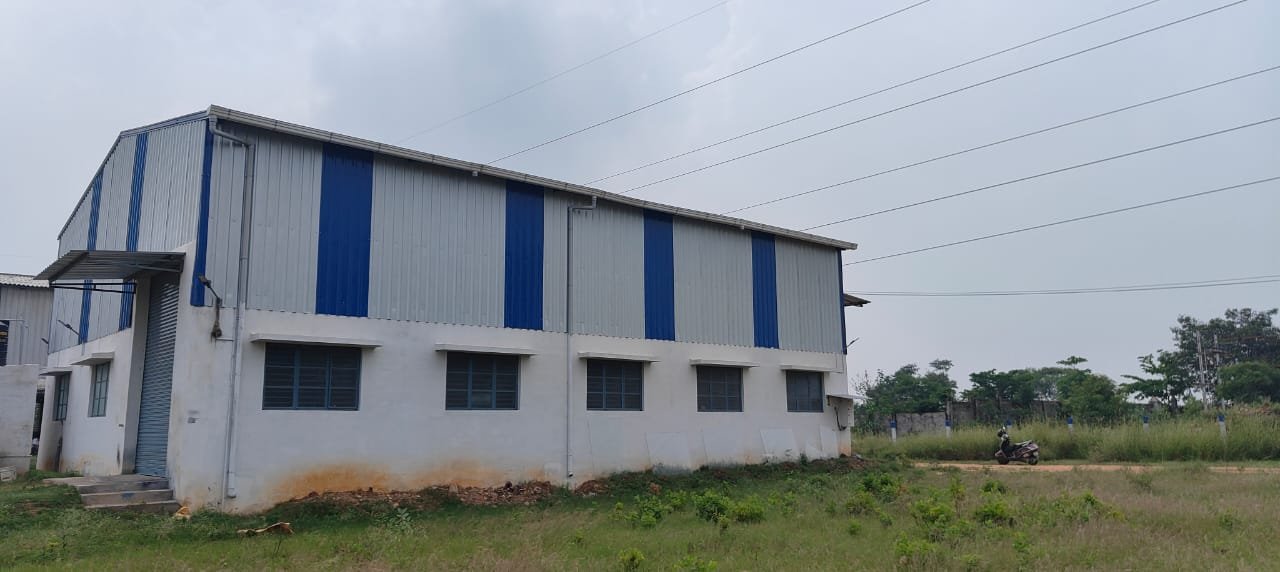 Approach road to Vedanth Industrial Zone with power transmission tower visible